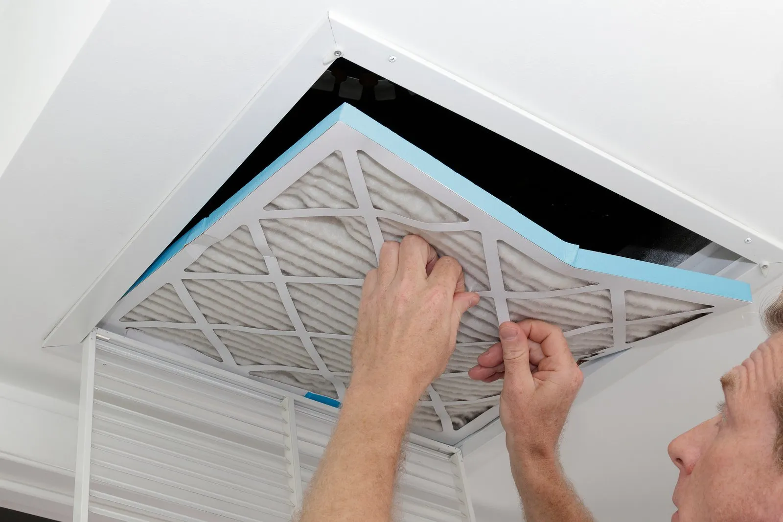 Technician cleaning an air duct vent in a Ponte Vedra Beach home